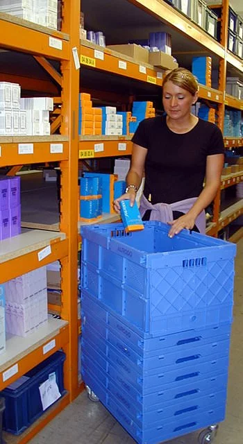 Unloading goods from plastic collapsible containers in a warehouse