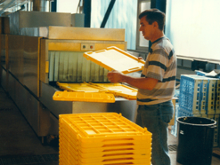 Utz employee operating washing machine for containers and trays