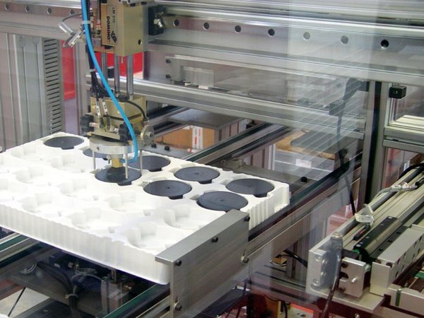 Automated arm places plastic parts in a thermoformed component holder